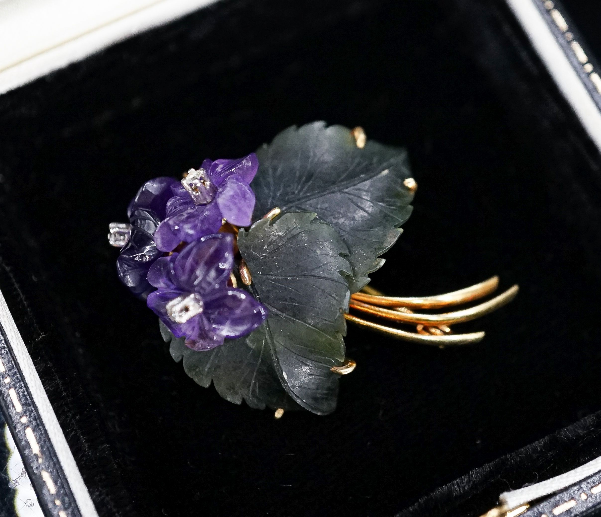 A continental Austrian? 585 yellow metal, diamond chip, carved nephrite and carved amethyst set flower head brooch, 39mm, gross 8.5 grams.
